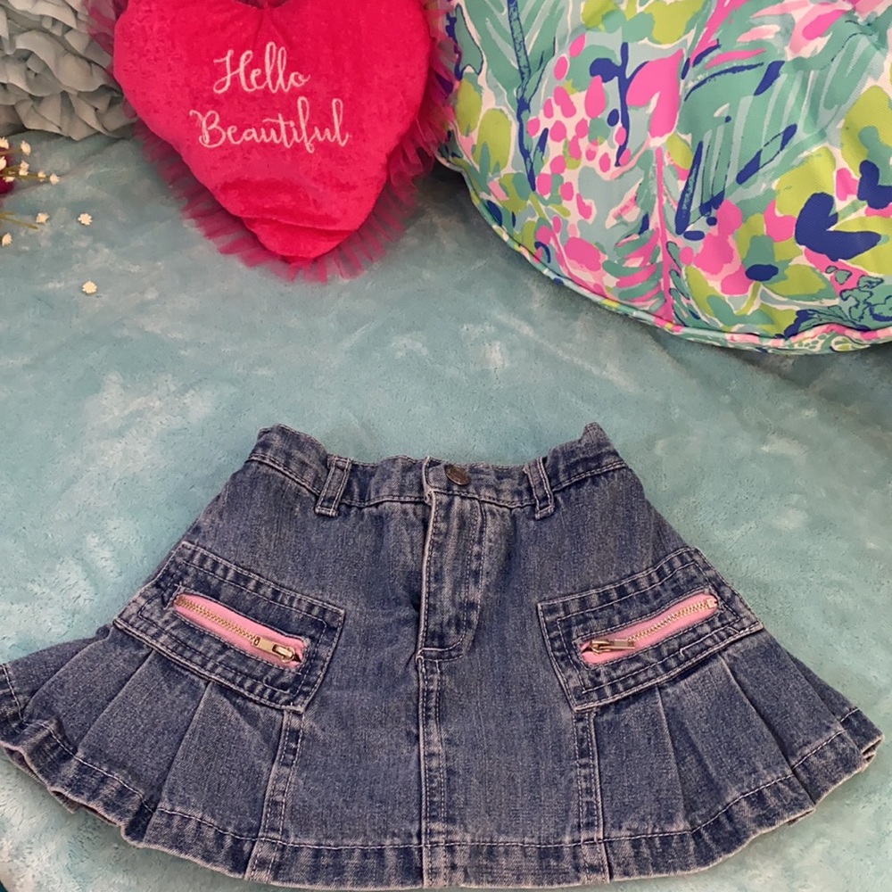 Light blue denim skort with pink trimmed zippers